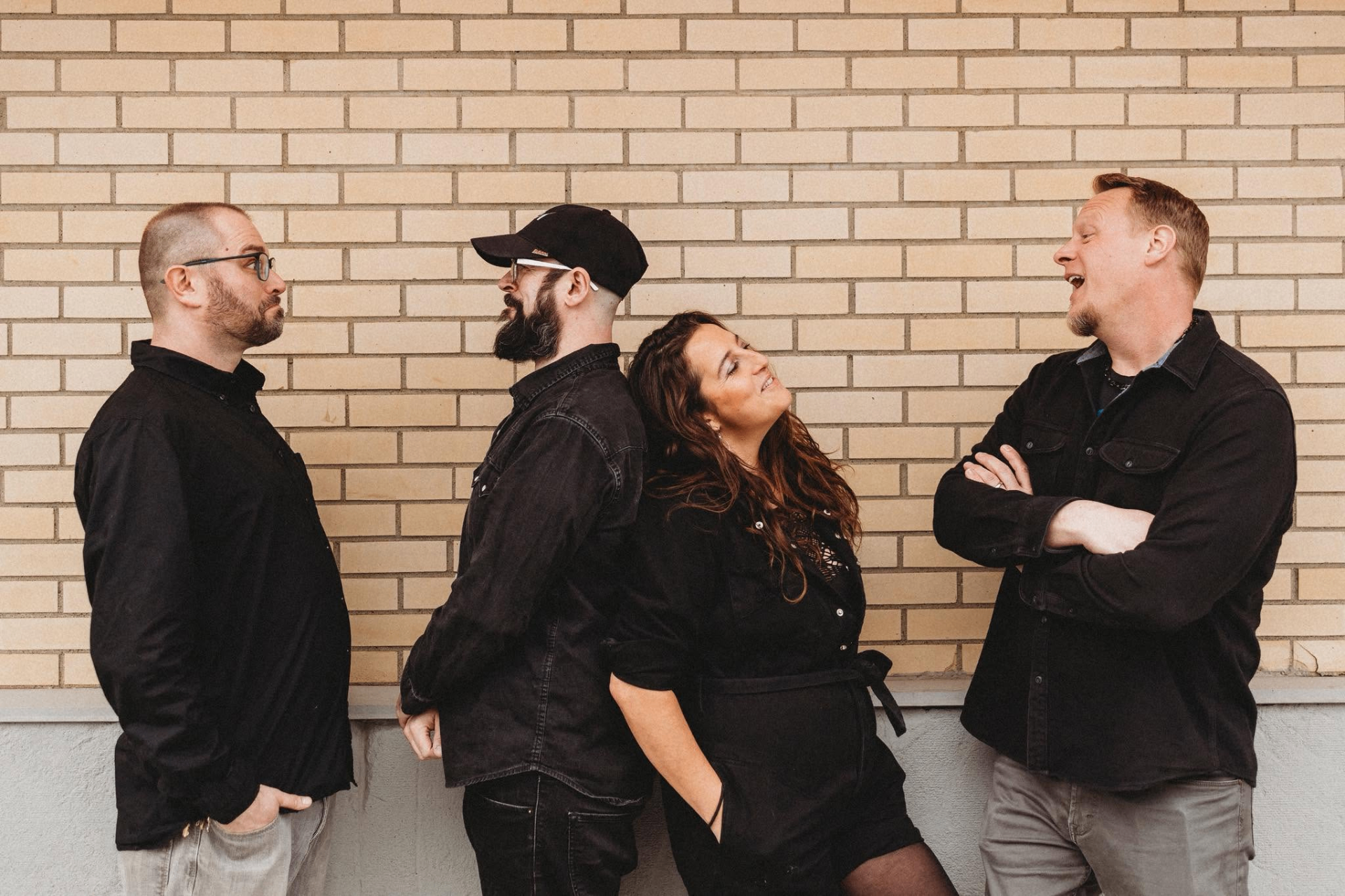 Penumbra band portrait posed against a brick wall